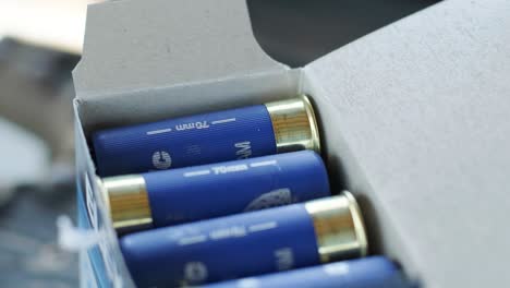 closeup weathered blue ammo cartridges for modern firearm stacked together in box