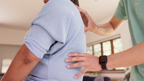 physiotherapist assisting senior woman with back exercises during therapy session