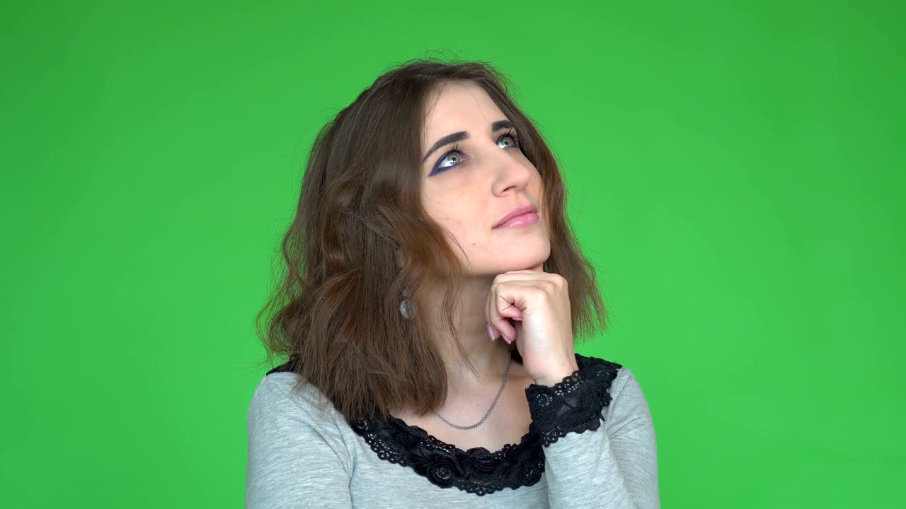 face expressions and emotions. Thoughtful young pretty woman holding hand under her head is thinking