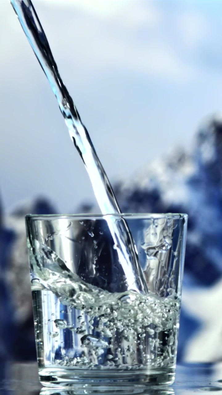 Acqua limpida che si versa in un bicchiere al rallentatore