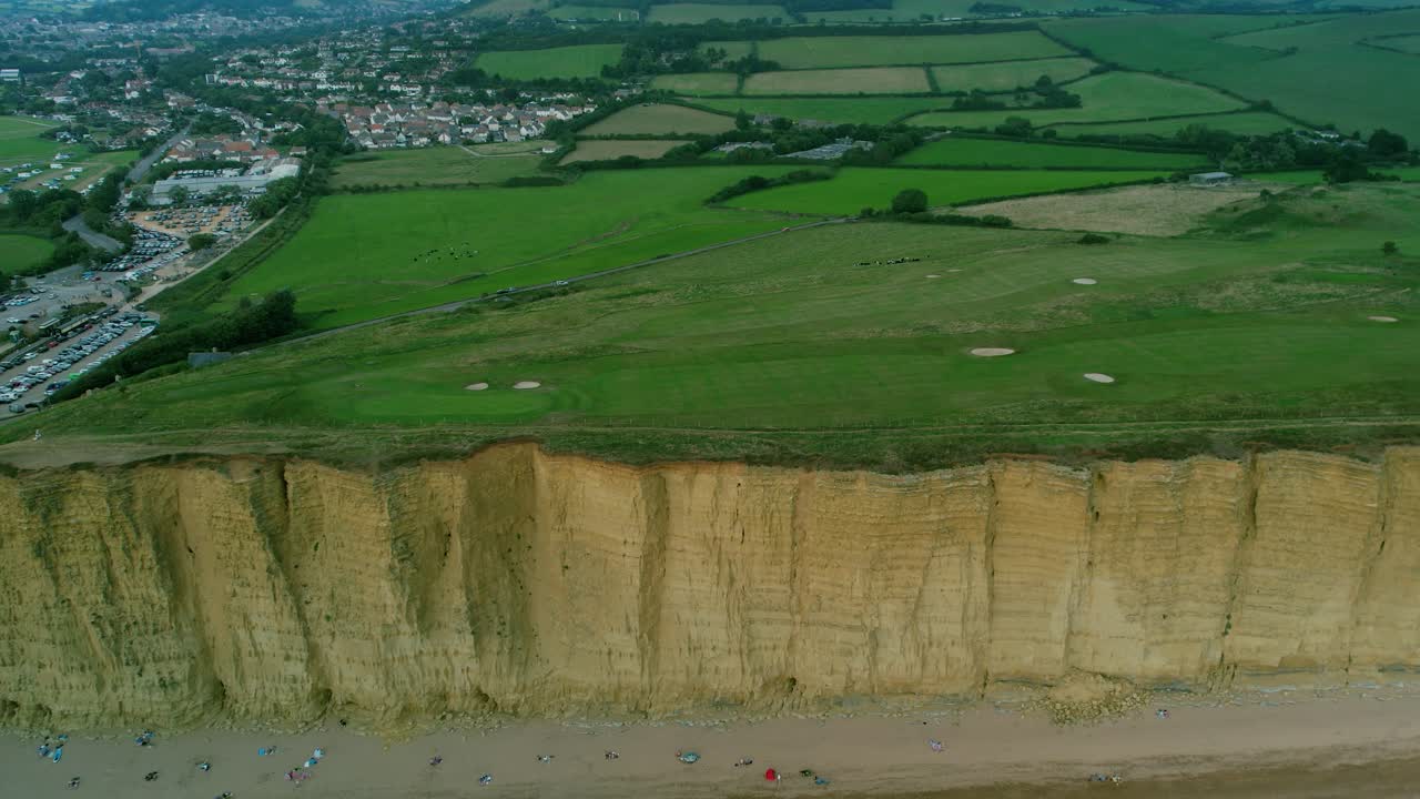 bridport west bay cliffs campo de golf de la campiña británica antena retroceder revelar arriba de la costa del océano turquesa