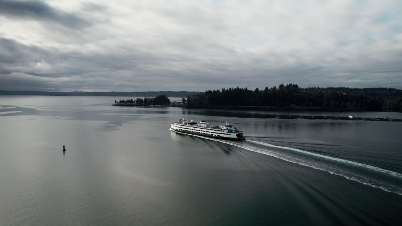 un ferry del estado de washington navega hacia aguas abiertas, las nubes oscuras y sombrías reflejan, la antena