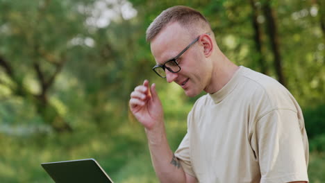 focused caucasian looks at his laptop screen closely. man working remotely having some problems with work.