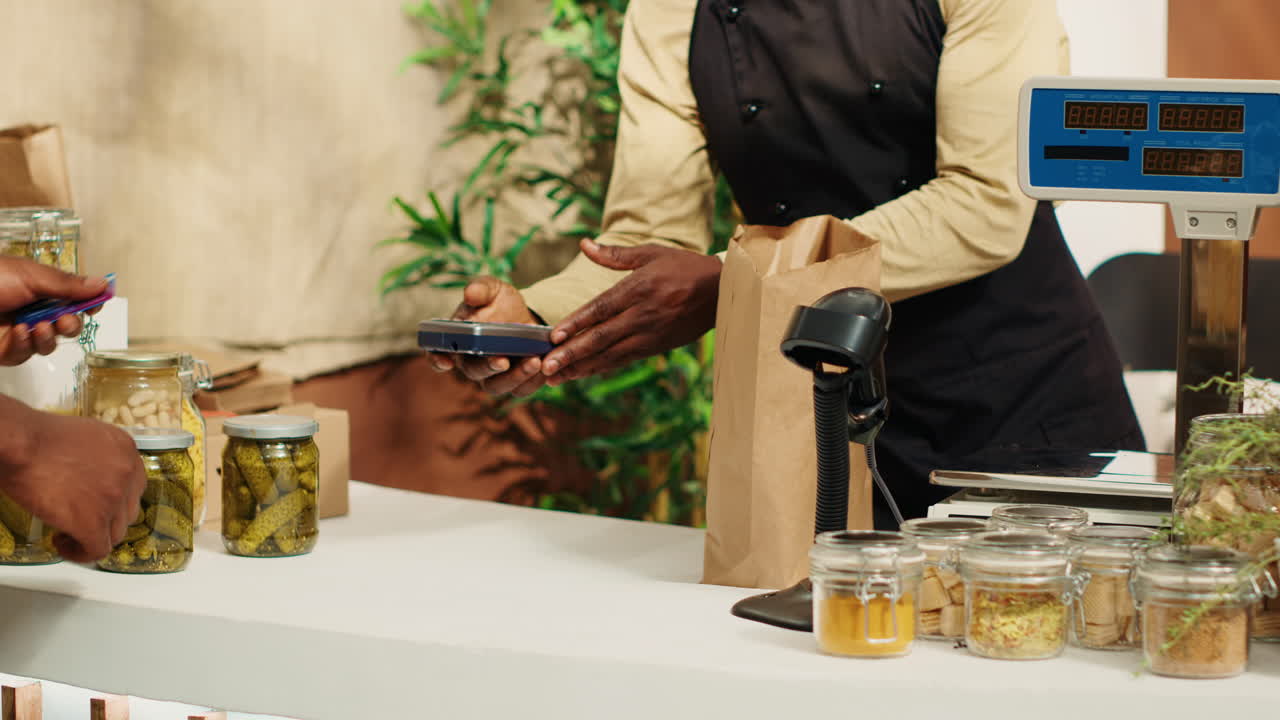 cliente vegano usando tarjeta en pos para pagar por alternativas de alimentos naturales