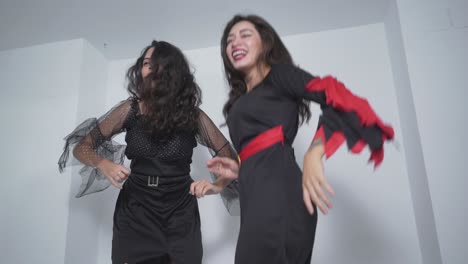 two women in halloween costumes dancing and having fun