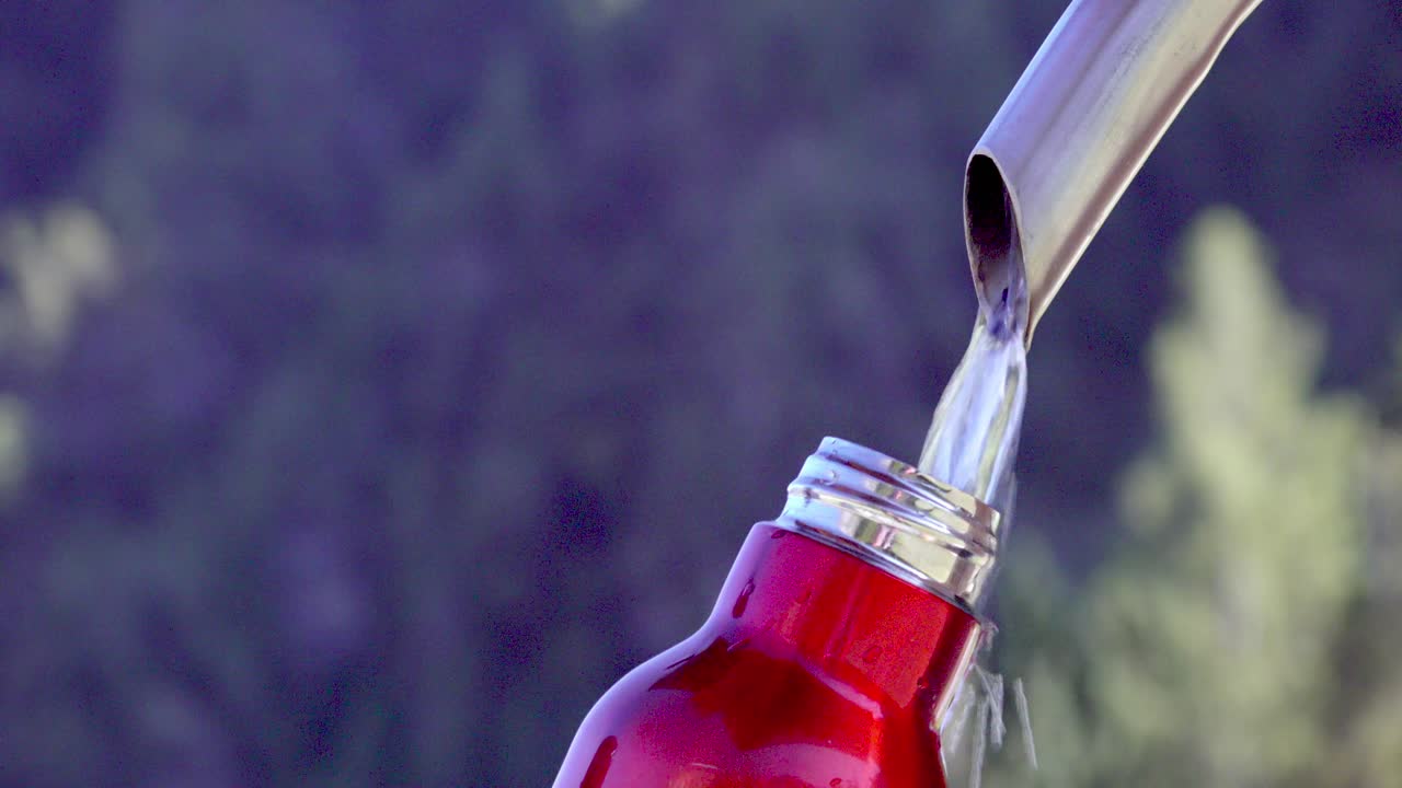 빈 테르모스 병이 분수 에서 물로 가득 차 있습니다.