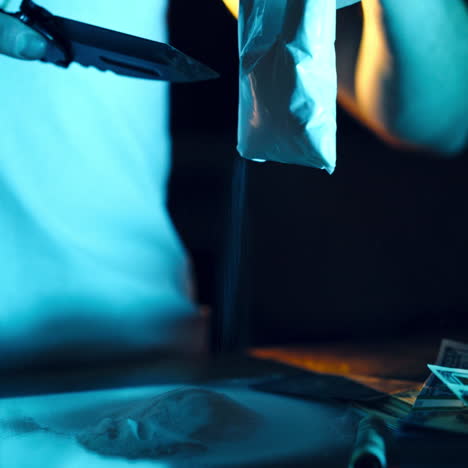 drug dealer takes a package with a drug and cuts it with a knife to sample it. abuse of drugs. criminal business