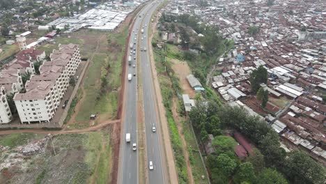 Aerial-view-of-traffic-on-highway-dividing-modern-residential-buildings-and-poor-neighborhood