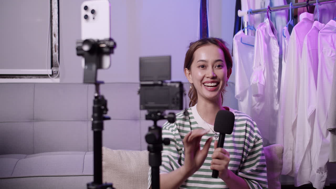 A female influencer testing the microphone while facing the cameras in front of her.