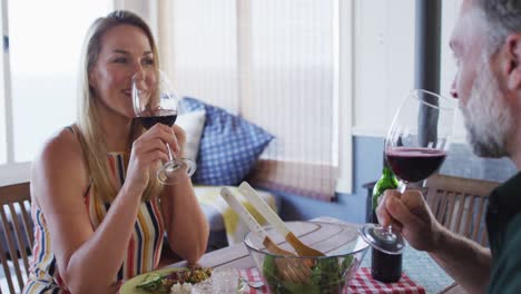 feliz pareja caucásica madura sonriendo, hablando y disfrutando de la comida juntos