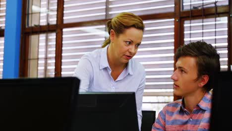 maestro ayudando a los estudiantes en la clase de computadora