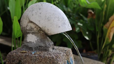 agua que fluye de una fuente de piedra esférica