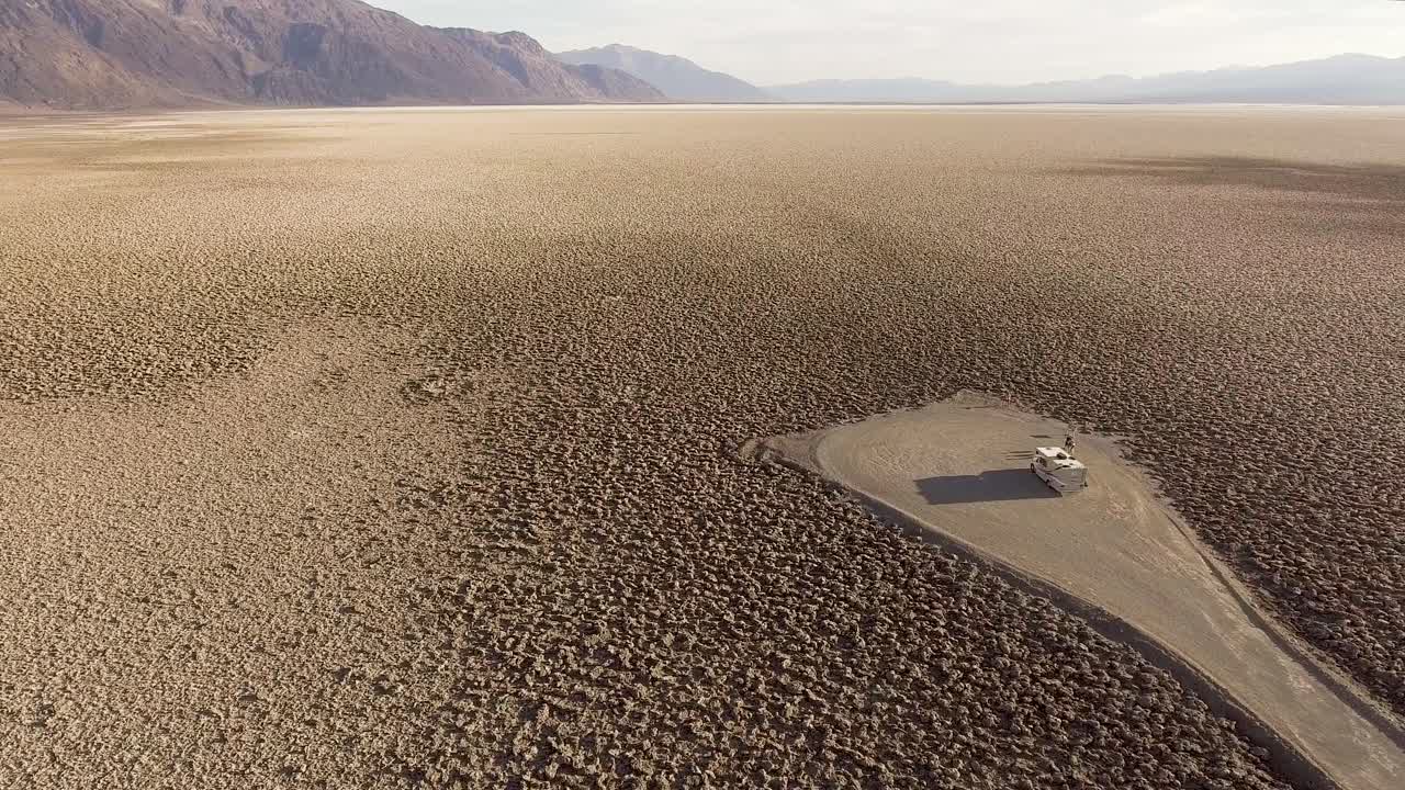 A crater landscape in California in the front is a RV