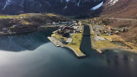 Stunning-aerial-view-of-Flam-Norway---Beautiful-spring-day-with-sunlight-and-reflections-in-sea---Aerial-watching-town-with-cruiseport-and-river-from-the-seaside