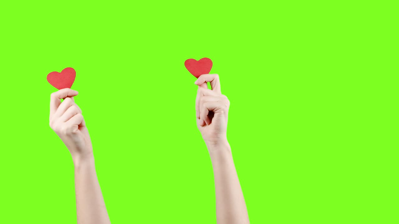 blogger mujer sostiene en las manos pequeños corazones rojos en la pantalla verde. como en la red social. día de san valentín, día internacional de la mujer, amor