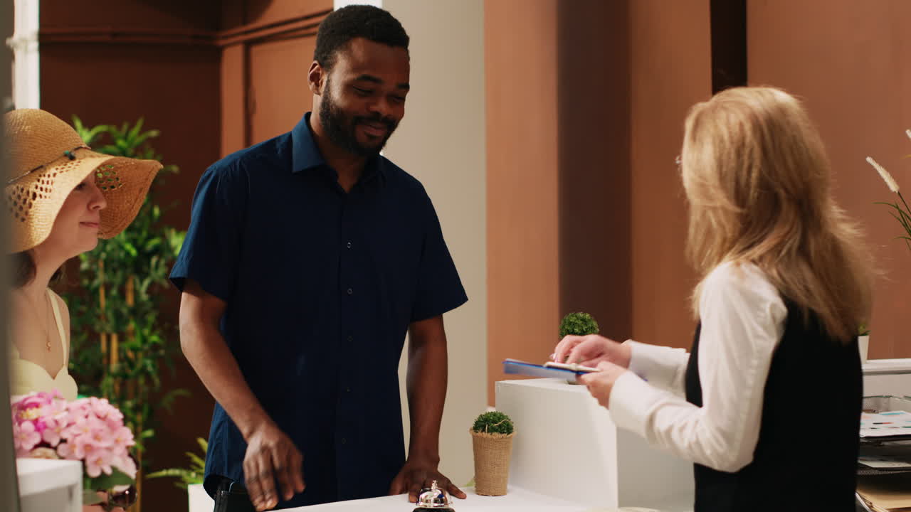 pareja feliz registrándose en el hotel