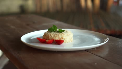 little napoleon cake with strawberries on top standing on a white plate
