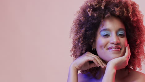 mujer biracial con cabello oscuro en luz azul y rosa con espacio de copia, cámara lenta