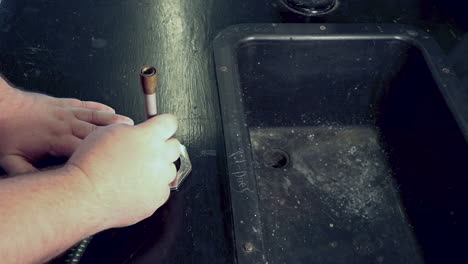 ajuste del tubo de entrada de aire en un mechero bunsen en un banco de laboratorio de química de la escuela secundaria