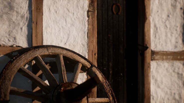 vecchia ruota di legno e porta nera alla casa bianca