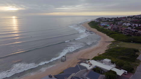 Südafrika-Drohnenantenne-Jeffreys-Bay-Surfstadt-Atemberaubender-Sonnenaufgang-Am-Frühen-Morgen-Goldene-Sonne-Auf-Dem-Ozean-Surferwelle-Wellengang-Sonnenaufgang-Sonnenuntergang-Drohne-Jbay-Küstenlinie-Strand-Filmische-Rückwärtsbewegung