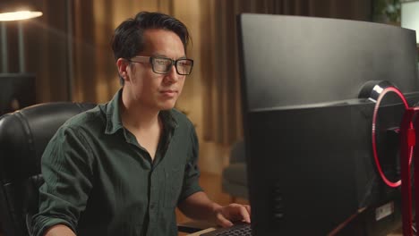 asian male thinking while works on his personal computer, he works late at night