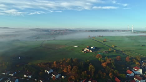 scenic aerial landscape of rural village area in germany, morning mist covered agricultural land