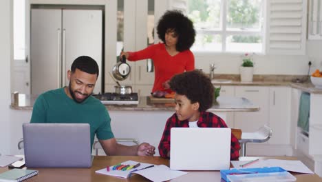 Padre-E-Hijo-Usando-Una-Computadora-Portátil-En-Casa