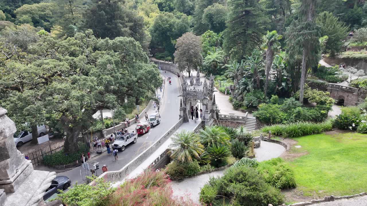 A winding garden path with lush greenery and stone walls at Quinta da Regaleira in Sintra, Portugal
