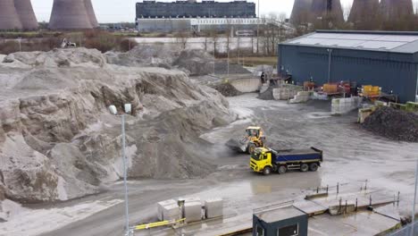 aerial view lorry waiting for earthmover load on british industrial power station coal operation site, zoom in