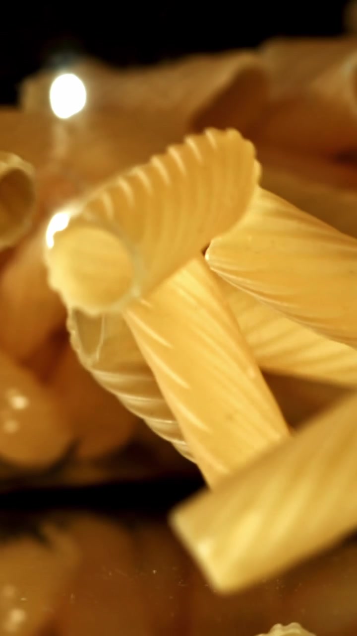Rigatoni crudi che cadono al rallentatore
