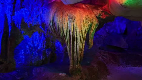 a beam of vibrant light casting hues over a limestone formation resembling an elephant at kek look tong cave in ipoh, malaysia - close up