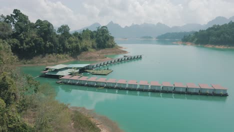 Hermosas-Imágenes-De-Drones-Que-Revelan-Los-Bungalows-Sobre-El-Agua,-La-Selva-Tropical-Y-La-Cordillera-En-El-Parque-Nacional-De-Khao-Sok,-Tailandia