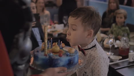 celebración de cumpleaños niño soplando velas en el pastel