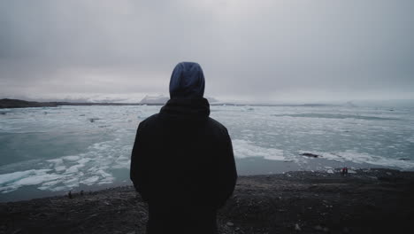 person contemplating a glacier lake in iceland