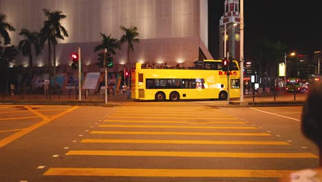 a bus waits as pedestrians cross the road