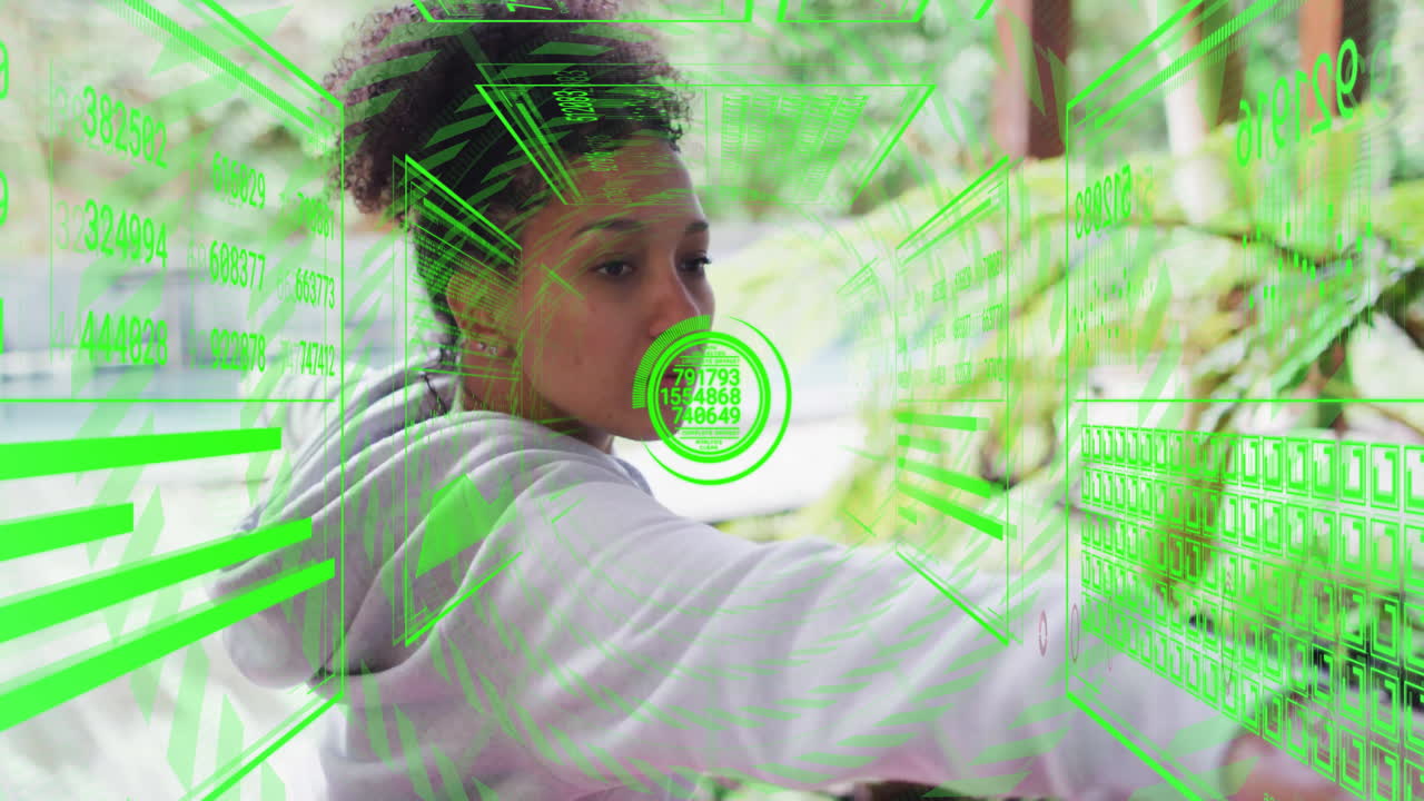 Interacting with futuristic green digital animation, woman focused on virtual screen