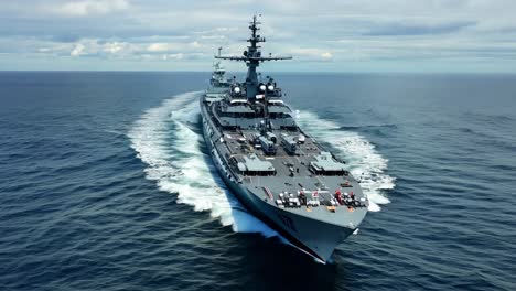 a grey naval warship sailing on the open ocean