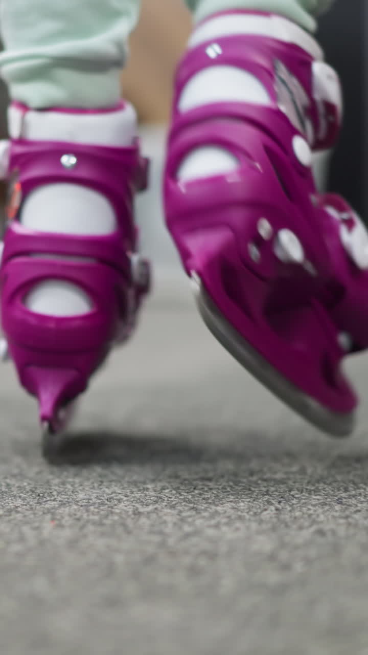 Close-up of someone walking in purple ice skates with ash-colored trousers, the scene captures the dynamic motion and preparation for ice skating