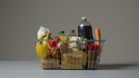 studio shot of basic food items in supermarket wire shopping basket 3