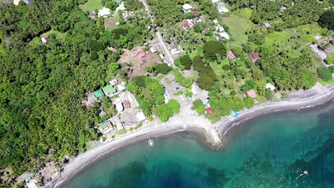 Aerial-view-of-a-little-town-with-sea-in-Negros-Oriental,-Philippines,-during-a-sunny-day