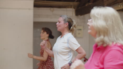 side view of senior women running in place in dance studio