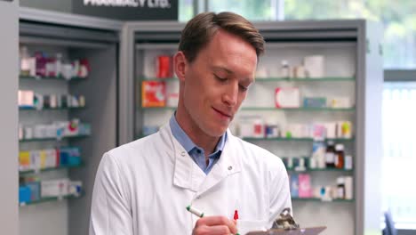 handsome pharmacist writing on clipboard