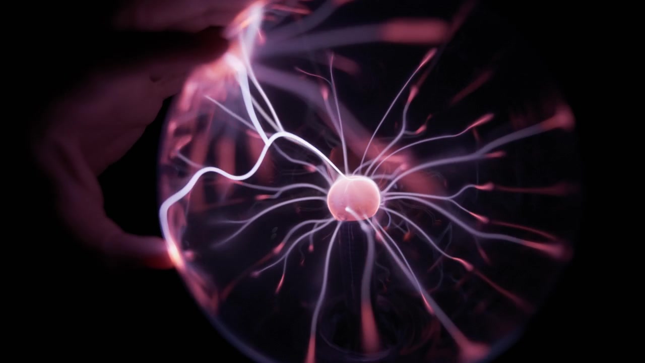 Mano che tocca una sfera di plasma elettrico con raggi di energia all'interno