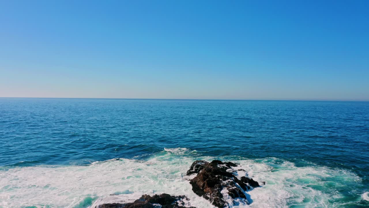 Waves hitting a rock in the middle of the Pacific Ocean.