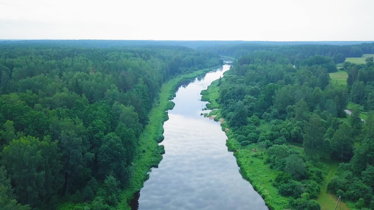vista aérea de un río venta en un día soleado de verano, exuberantes árboles y prados verdes, hermoso paisaje rural, tiro de drones de gran angular a gran altitud avanzando