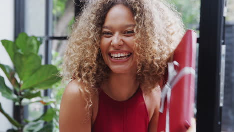 Portrait-Of-Woman-By-Tree-Shaking-Christmas-Present-Trying-To-Guess-Contents