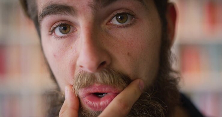 Primo piano di un giovane uomo che si cura la barba
