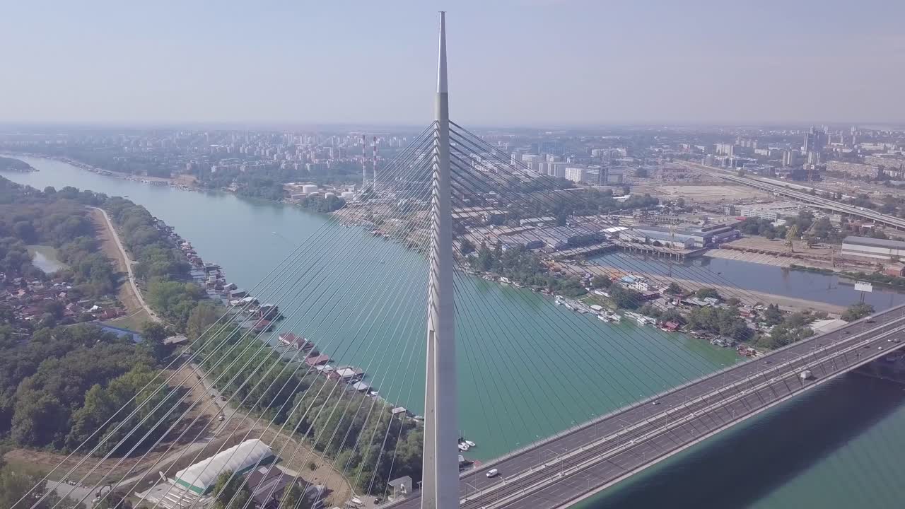 impresionante órbita aérea de 4k estableciendo una toma del río sava y el puente ada en belgrado