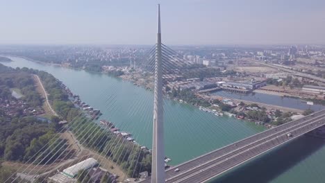 impresionante órbita aérea de 4k estableciendo una toma del río sava y el puente ada en belgrado